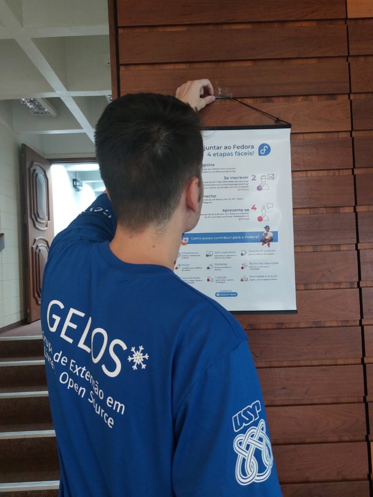 Staff member placing How to Join Fedora banner