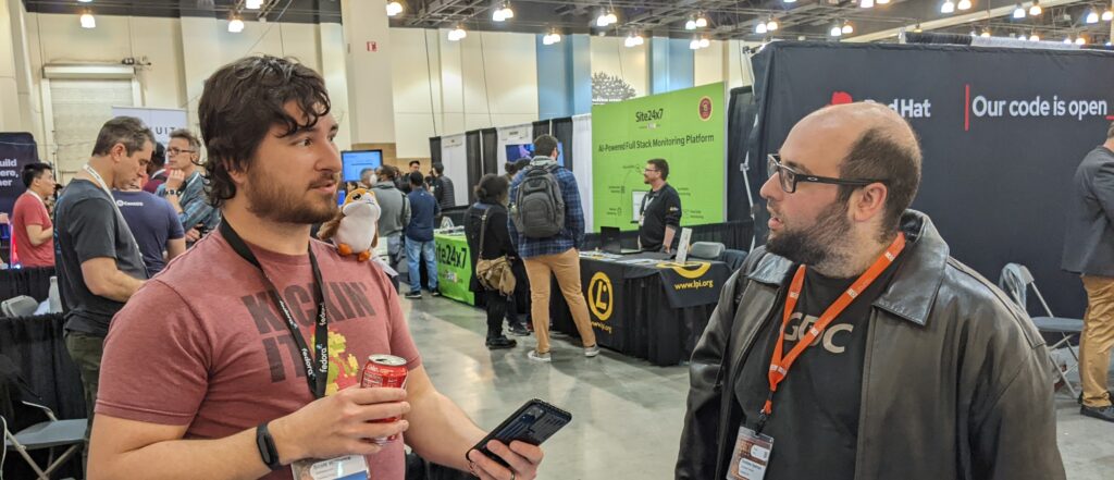A picture of Fedora Ambassador Scott Williams speaking with Andrew Ajemian